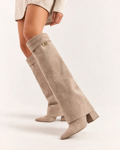 Beige suede-effect knee-high boot showing the folded cuff, small gold badge, pointed toe and block heel.